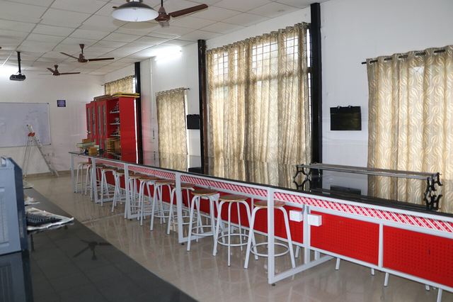 A school physics laboratory with a long bench and a row of stools.